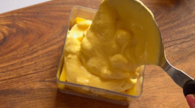 No-bake mango cheesecake jar topped with cream and fresh mango pieces